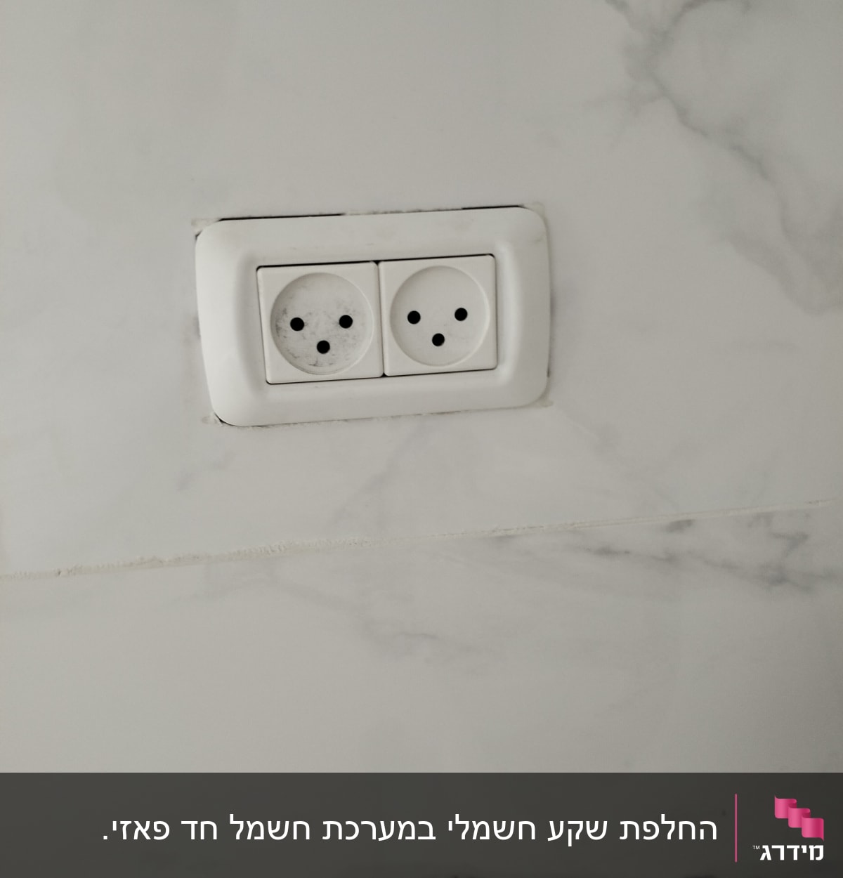 שקע חשמל כפול על קיר שיש לבן